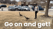 a man standing in front of a row of cars with the words go on and get on the bottom