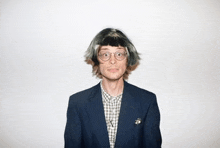 a man wearing a wig and glasses is wearing a suit