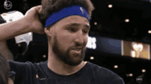 a man with a beard wearing a blue headband with the letter b on it