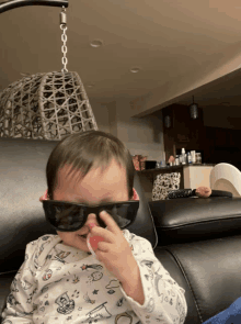 a baby wearing sunglasses is sitting on a chair