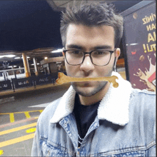 a man wearing glasses has a bone sticking out of his mouth in front of a sign that says ' silly milk '