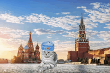 a cat wearing a blue hat with a star on it is laying in front of a clock tower