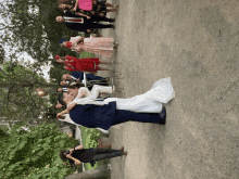 a bride and groom are kissing in front of a crowd of people