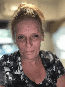 a close up of a woman 's face with a bun on her hair