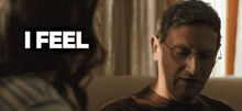 a man wearing glasses is sitting on a couch with the word i feel above him