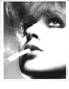 a close up of a woman smoking a cigarette in a black and white photo