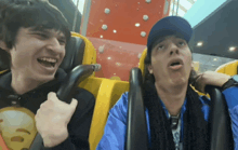 two men are riding a roller coaster and one of them is wearing a shirt that says ' smiley face ' on it