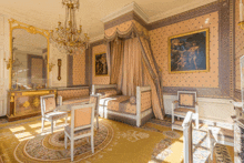 a bedroom with a canopy bed and chairs