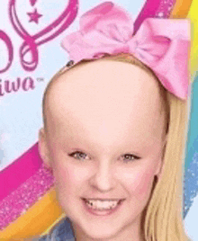 a girl with a bald head and a pink bow on her head .