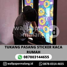 a man is installing a stained glass window sticker