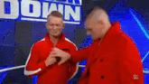 two men are standing in a wrestling ring without shirts .