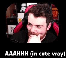 a man with a beard is sitting in a red and black chair with the caption aaahhh ( in cute way )