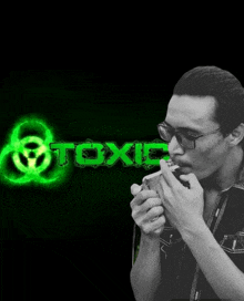 a man is smoking a cigarette in front of a green toxic logo