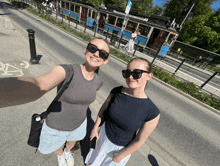 two women are taking a selfie in front of a trolley that says " trolley " on it