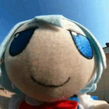 a close up of a stuffed animal with blue eyes and a smile on its face .