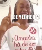 a woman wearing a t-shirt that says ee yeoreum is giving a peace sign .
