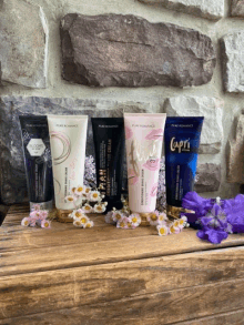 four bottles of pure romance lotion are lined up on a wooden table