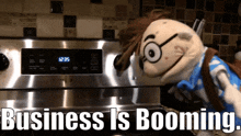 a puppet is standing in front of a stove with the words business is booming