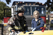 a fireman and a paramedic stand in front of a chicago fire department fire truck