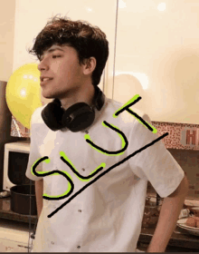 a young man wearing headphones and a white shirt has the word slut written on his shirt