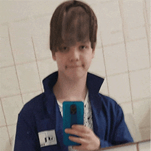 a young boy is taking a selfie in front of a mirror