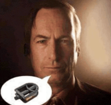 a man in a suit and tie is holding a bicycle pedal in front of his face in a speech bubble .