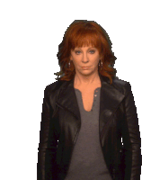 a woman with red hair is wearing a black jacket