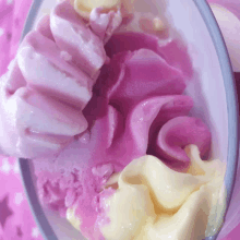 a bowl of pink and yellow ice cream on a pink background