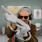 a man wearing a wig and headphones is holding a pair of gloves