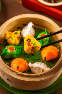 a person is taking a dumpling from a bamboo steamer