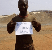 a man in a brown shirt holds up a sign that says bize heryer sivas