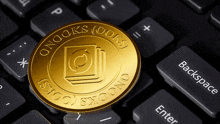 a gold coin on a keyboard that says onooks