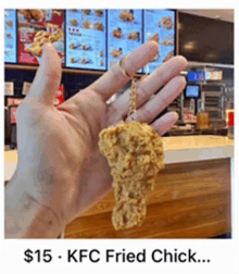 a person is holding a kfc fried chick keychain