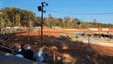 a group of people are watching a race on a dirt track with a sign that says do not enter