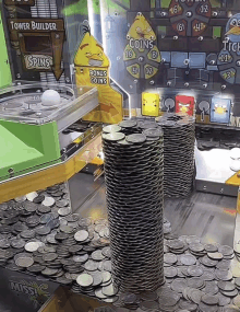 a stack of coins sits in front of a tower builder machine