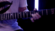 a close up of a person playing a guitar with the letter k on it