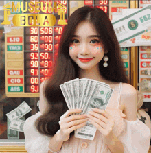 a woman holding a bunch of money in front of a sign that says bola