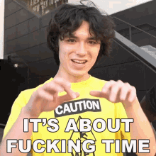 a man wearing a yellow shirt that says caution