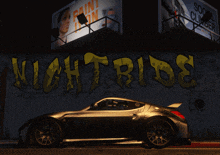 a car is parked in front of a wall that says nightride on it