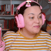 a woman wearing pink headphones with a penguin headband on her head