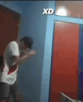 a man is standing in a room with a xd sign on the wall
