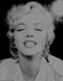 a black and white photo of marilyn monroe blowing a kiss