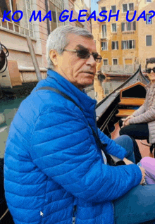 a man in a blue jacket is sitting on a gondola with the words koma gleashua on the top