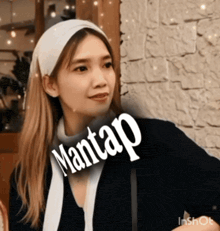 a woman wearing a white headband has the word mantap on her neck