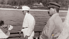 a black and white photo of two men standing on a boat with the words south africa on the bottom left