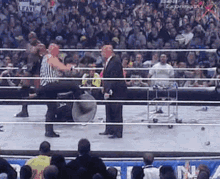 a referee is standing in the middle of a wrestling ring with a sign that says leave in the background