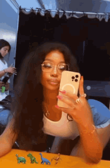 a woman wearing glasses is taking a picture of herself with her phone