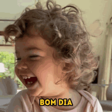 a little girl with curly hair is smiling with the words bom dia above her head