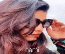 a close up of a woman wearing sunglasses with the word nami written on the bottom .