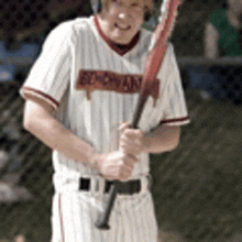 a man in a baseball uniform is holding a baseball bat